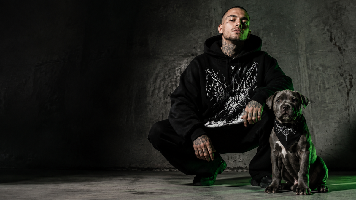 A punk styled figure and a dog in dark streetwear